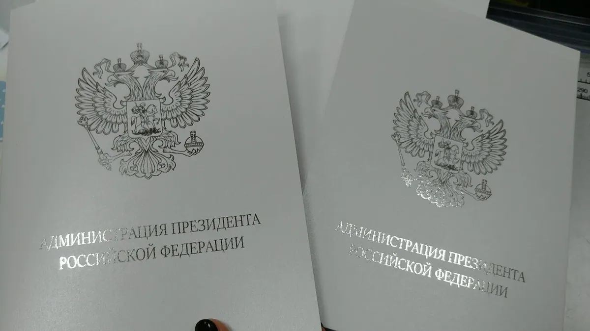 Белые папки с фольгированием серебряной фольгой герба и надписи Администрация Президента Российской Федерации
