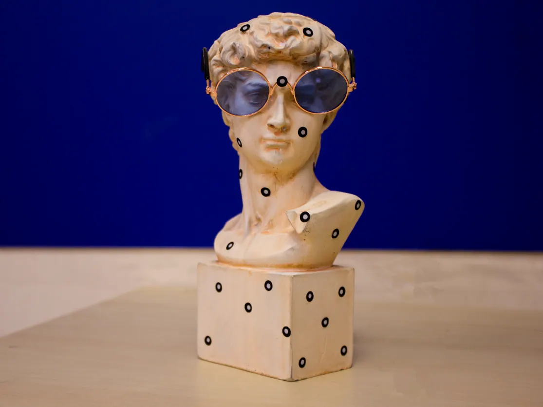 Гипсовый бюст в темных очках с наклеенными круглыми маркерами для 3D-сканирования