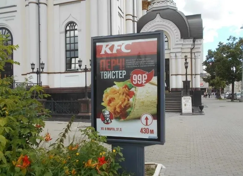 Рекламный сити-формат с постером KFC на пешеходной улице