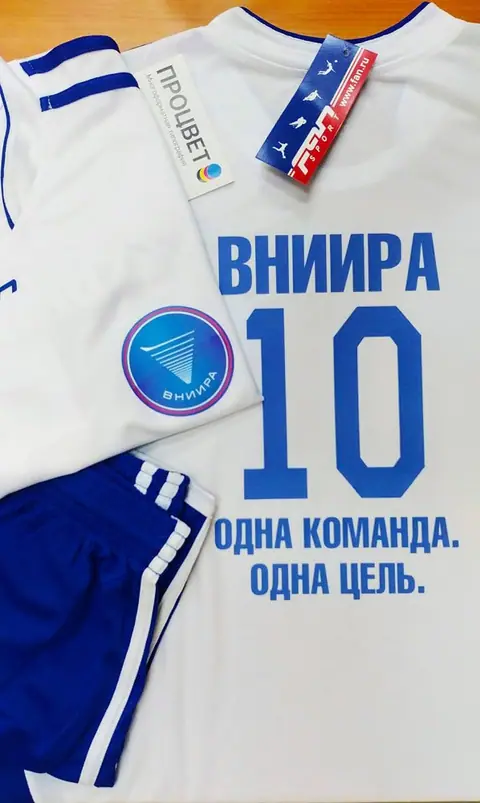 Белая футбольная форма с синим номером, логотипом и девизом команды